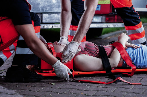 Paramedics treating a woman experiencing cardiac arrest and AED injury. Paramedics treating a woman experiencing cardiac arrest and AED injury.